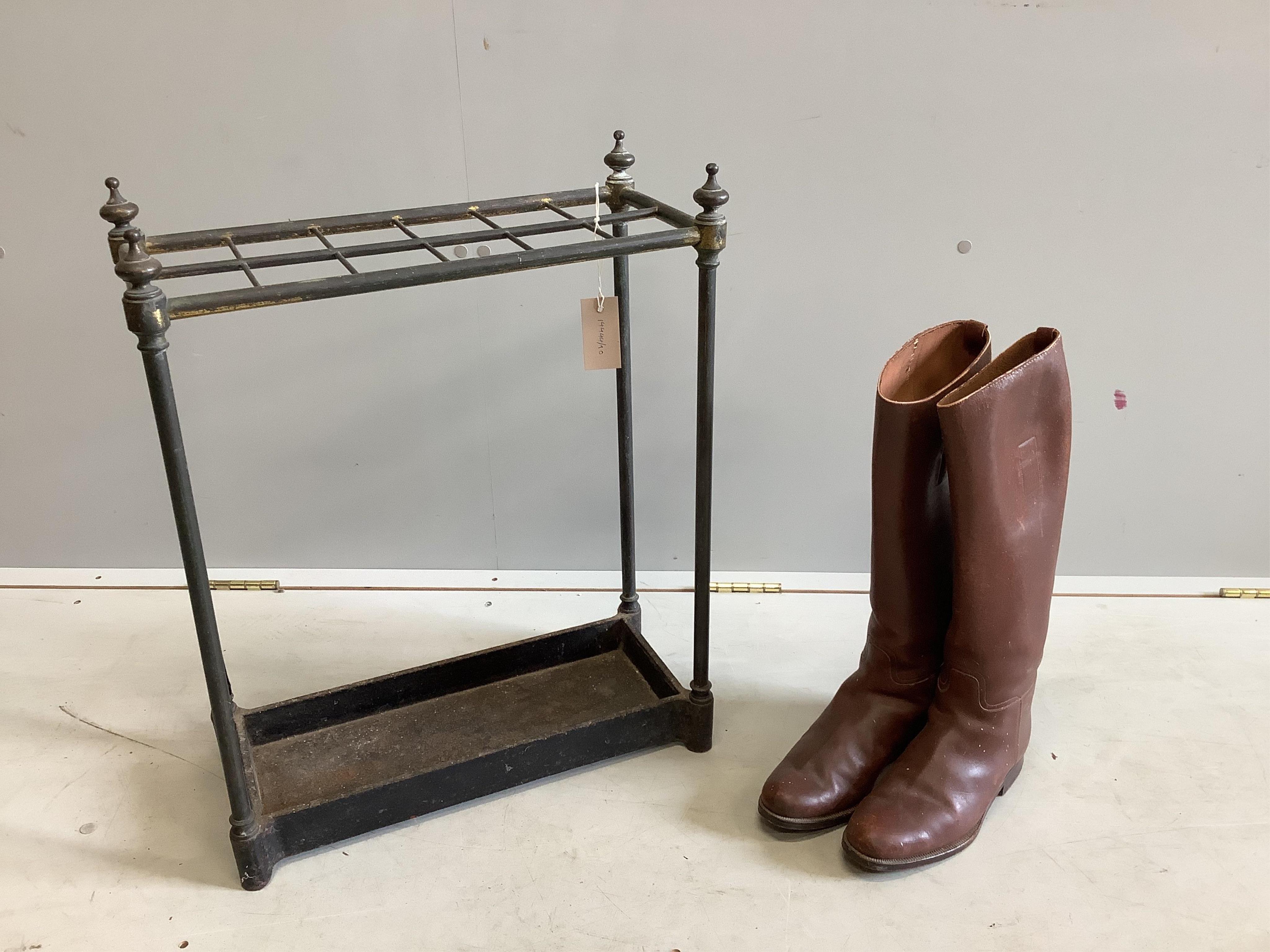An early 20th century tubular brass and cast iron twelve division stick stand, width 50cm, height 61cm together with a pair of vintage tan leather riding boots. Condition - poor